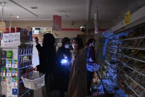 Người dân vội vàng mua sắm trong một cửa hàng tiện lợi bị mất điện ở Tokyo sau trận động đất mạnh 7,3 độ richter vào ngày 16-3.