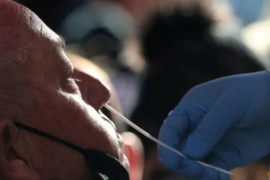 Nhân viên y tế đang lấy mẫu xét nghiệm COVID-19 cho một người đàn ông ở Quảng trường Thời đại, TP New York, Mỹ, ngày 26-12-2021.