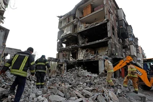 Lực lượng cứu hộ có mặt tại một tòa nhà dân cư bị hư hại sau các cuộc không kích của Nga ở TP Mariupol, Ukraine ngày 19-4.