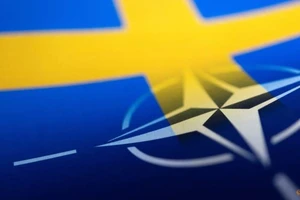 Quốc kỳ Thụy Điển và cờ NATO được in trên giấy.