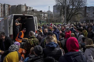 Người dân nhận viện trợ nhân đạo trong sân một trường học ở TP Chernihiv, phía bắc Ukraine.