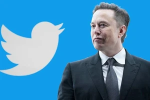 Tỉ phú Elon Musk đứng trước logo nền tảng mạng xã hội Twitter.