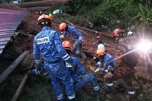 Lực lượng cứu hỏa và cứu hộ Malaysia tìm kiếm những nạn nhân mất tích sau vụ lở đất ở bang Selangor vào sáng sớm ngày 16-12.