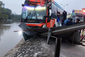 Ô tô khách lao xuống bờ sông sau va chạm với xe trộn bê tông