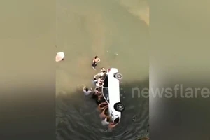 Hồi hộp giải cứu cả gia đình mắc kẹt khi xe lao xuống sông