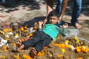 Cha mẹ ném con vào đống phân bò để cầu may