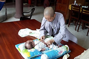 Bé trai quấn trong khăn bị bỏ rơi trước cổng chùa