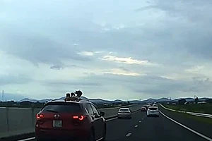 Nhiều trẻ em đưa người ra cửa sổ trời ôtô trên cao tốc