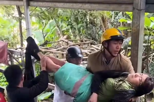 Nghẹt thở giải cứu người phụ nữ bám víu lùm cỏ giữa lòng nước lũ 