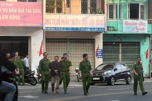 Cảnh sát đưa giám đốc Trung tâm dịch vụ đấu giá Lâm Đồng lên xe đặc chủng