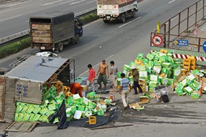 Xe tải chở nước ngọt lật nhào, nhiều người xông vào 'hôi của'