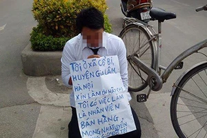 Nam thanh niên đeo bảng, quỳ gối trước cổng đài truyền hình xin việc