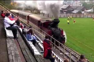 Xe lửa đi qua là các CĐV bị gián đoạn xem bóng đá. ẢNH: THE SUN