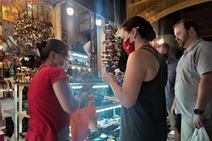 Nhóm du khách mua hàng lưu niệm tại chợ Bến Thành 