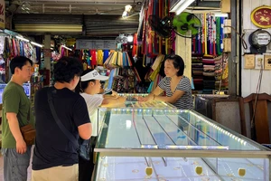 Khách hàng chọn mua trang sức tại cửa hàng trong chợ truyền thống. Ảnh: TÚ UYÊN