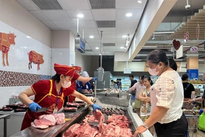 Người dân mua thịt heo ở siêu thị. Ảnh: TÚ UYÊN