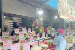 Người tiêu dùng mua gạo ở chợ. Ảnh: TÚ UYÊN