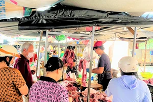 Người tiêu dùng mua thịt heo ở chợ. Ảnh: TÚ UYÊN