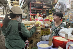 Người tiêu dùng mua sắm tại sạp tạp hóa. Ảnh: TÚ UYÊN