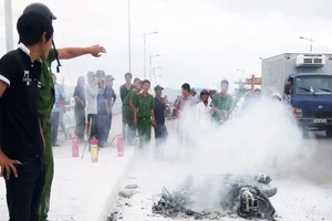 Xe máy đang chạy trên cầu đột ngột bốc cháy trơ khung