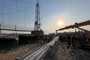 Lực lượng cứu hộ tìm kiếm những người sống sót sau vụ sập cầu bang Gujarat (Ấn Độ). REUTERS