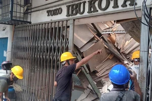 Công nhân kiểm tra một cửa hàng hư hại sau trận động đất ở khu vực Cianjur, tỉnh Tây Java (Indonesia) ngày 21-11. Ảnh: CNN