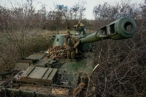 Lính pháo binh Ukraine đứng trên khẩu lựu pháo gần một vị trí tiền tuyến không được tiết lộ ở miền đông Ukraine. Ảnh: AFP 