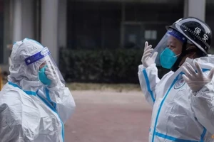 Nhân viên y tế chuẩn bị vào một tòa nhà chung cư ở Bắc Kinh vào ngày 2-12. Ảnh: REUTERS