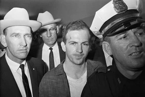 Ông Lee Harvey Oswald (giữa) sau khi bị bắt. Ảnh: THE NEW YORK TIMES