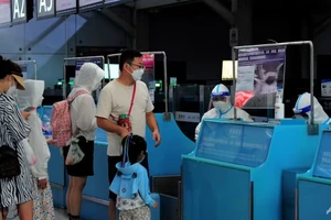 Khách du lịch làm thủ tục trước khi khởi hành tại sân bay quốc tế Phượng Hoàng Tam Á, thành phố Tam Á, đảo Hải Nam (Trung Quốc) ngày 9-8. Ảnh: AFP
