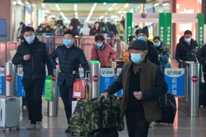 Hành khách đến nhà ga đường sắt ở TP Nam Kinh, tỉnh Giang Tô (Trung Quốc) ngày 16-1. Ảnh: AFP