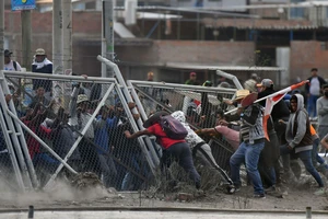 Người biểu tình kéo đổ hàng rào khi cố gắng vào sân bay ở thành phố Arequipa (Peru) ngày 19-1. Ảnh: CNN