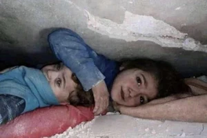 Bé gái 7 tuổi ở Syria che chắn cho em trai giữa đống đổ nát suốt nhiều giờ liền. Ảnh: TWITTER