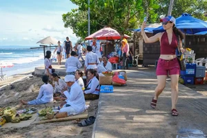 Một du khách nước ngoài tại bãi biển ở quận Kuta, tỉnh Bali (Indonesia). Ảnh: EPA