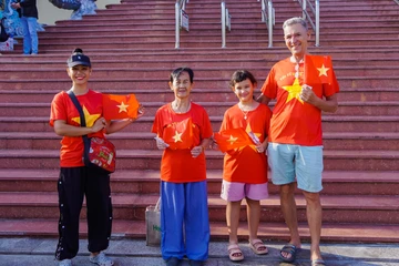 Khách quốc tế diện áo cờ đỏ sao vàng check-in tại khu vui chơi dịp lễ 30-4