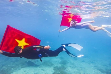 Bơi, lặn biển mang theo cờ Tổ quốc trên biển Quy Nhơn