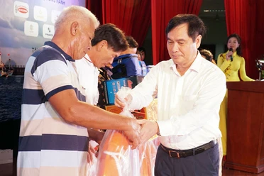 Ông Phan Xuân Thủy, Phó Trưởng ban Tuyên giáo Trung ương, đang trao các phần quà có ý nghĩa thiết thực của chương trình đến ngư dân Ninh Thuận.