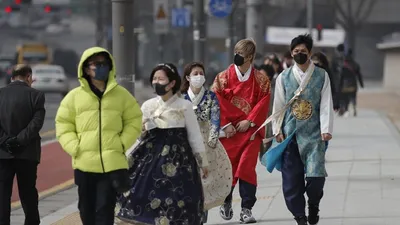 Du khách đeo khẩu trang ở Gwanghwamun, cổng chính vào cung điện Gyeongbok Palace, một danh thắng ở Seoul hôm 22-2. Ảnh: AP.