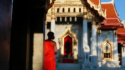 Một thầy tu mang khẩu trang tại một ngôi chùa vắng vẻ do dịch COVID-19 ở Bangkok (Thái Lan). Ảnh: REUTERS