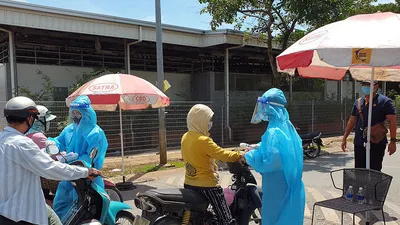 Người dân được kiểm tra thân nhiệt ở cổng vào chợ Bình Điền.