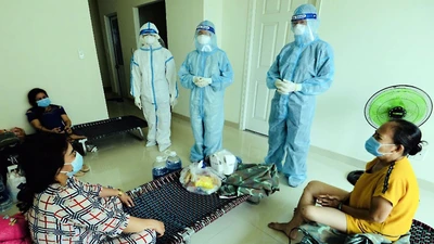 Sư cô Nhuận Bình (người mặc đồ bảo hộ ở giữa) đến các phòng bệnh nhẹ để động viên bệnh nhân.