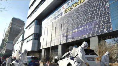 Nhân viên y tế đang tiến hành khử trùng bên ngoài nhà thờ ở TP Daegu. Ảnh: REUTERS