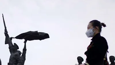 Một người phụ nữ đi ngang qua Tượng đài Cách mạng Tân Hợi ở Vũ Hán hôm 6-4. Ảnh: REUTERS