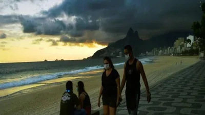 Người dân đeo khẩu trang đi dạo trên bãi biển ở Rio de Janeiro. Ảnh: AFP