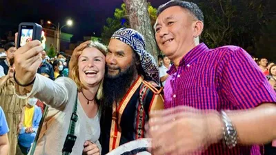 Du khách chụp ảnh lưu niệm cùng các nghệ nhân. Ảnh: LÊ KIẾN