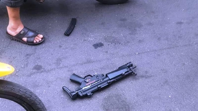 1 người nằm bất động và 1 khẩu súng vứt lại sau hỗn chiến