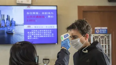 Kiểm tra nhiệt độ tại một bến phà chở khách ở Thượng Hải (Trung Quốc) ngày 30-1. Ảnh: BLOOMBERG