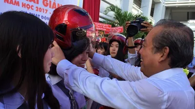Phó Thủ tướng Trương Hòa Bình đội mũ bảo hiểm cho HS