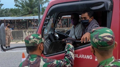 Binh sĩ kiểm tra việc chấp hành hạn chế đi lại trên một đường cao tốc ở TP Pekanbaru (Indonesia) ngày 22-4. Ảnh: GETTY IMAGES