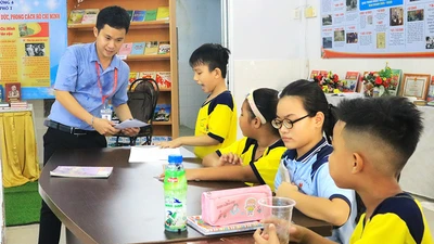 Thầy Lê Tấn Phát trong giờ dạy miễn phí cho các em nhỏ tại xóm trọ công nhân ở quận 4. Ảnh: VÕ THƠ